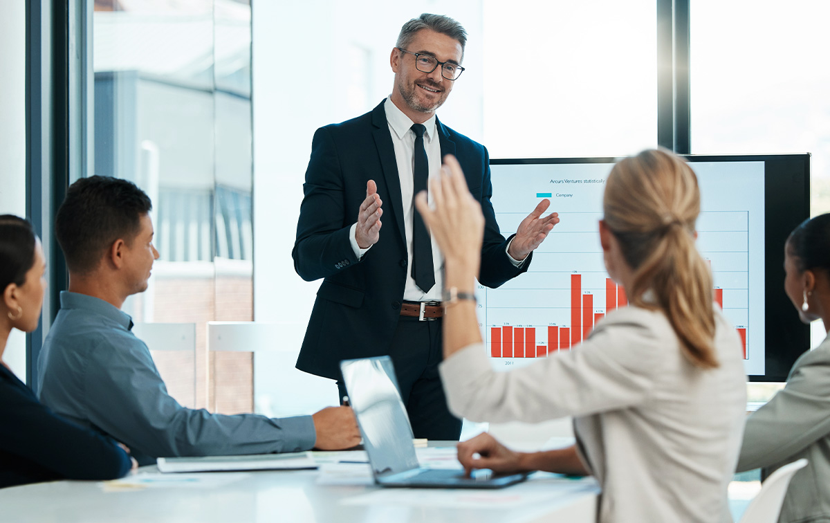 Lider IT prowadzący szkolenie dla zespołu, prezentujący zasady zarządzania sytuacyjnego na ekranie i&nbsp;angażujący uczestników.